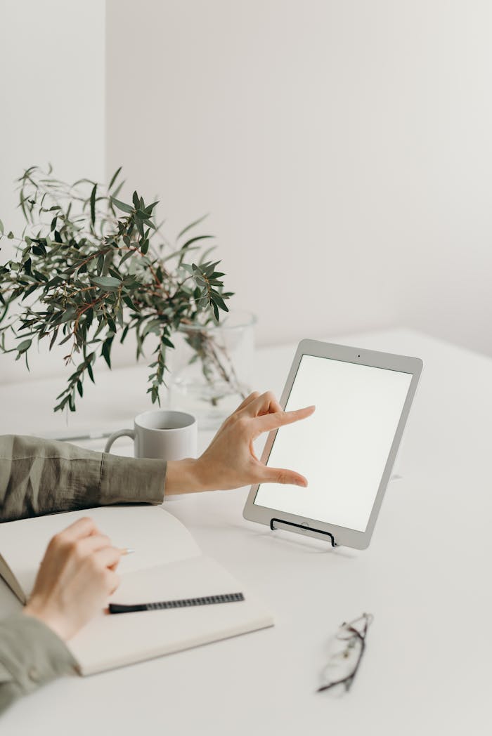 A minimalistic home office setup with a tablet and notebook, ideal for freelancers.